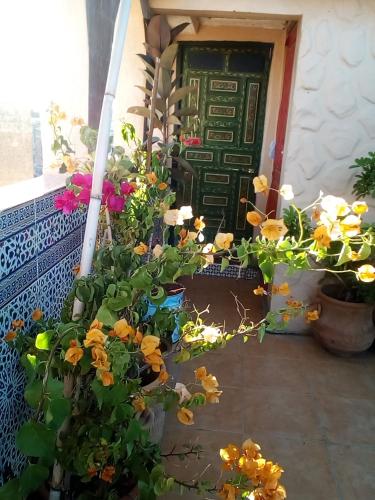a door with flowers in front of a building at Riad Malak in Meknès
