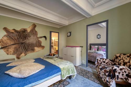 een slaapkamer met een bed en een grote boomtak aan de muur bij DREAM COLOR in Alignan-du-Vent