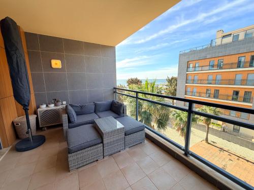 a balcony with a couch and a view of a building at Am Hafen - House Barbara 1 l Marina Olhão in Olhão