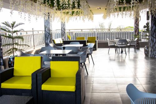 a restaurant with bright yellow chairs and tables at Nice-mason Serene and Suites in Benin City