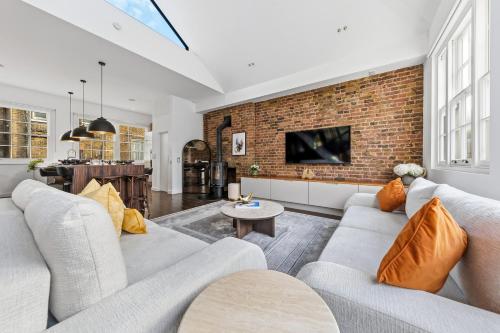 a living room with two couches and a brick wall at The Marylebone Villa in London