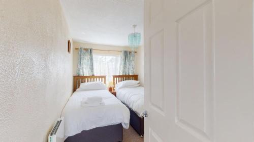two beds in a small room with a window at C37 Jupiter, Riviere Towans in Hayle