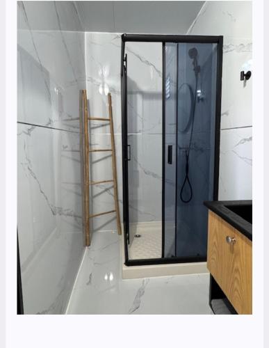a shower with a glass door in a bathroom at הבקתות של מאי in Ẕomeẖa