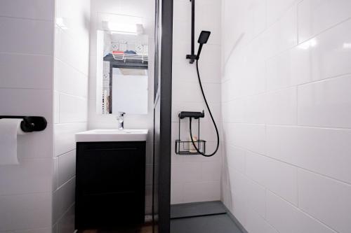 een kleine badkamer met een wastafel en een douche bij Studio Cabine Ax Les 3 Domaines in Ax-les-Thermes