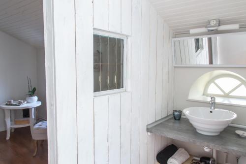 uma casa de banho branca com um lavatório e uma janela em Le coup de coeur em Coincy