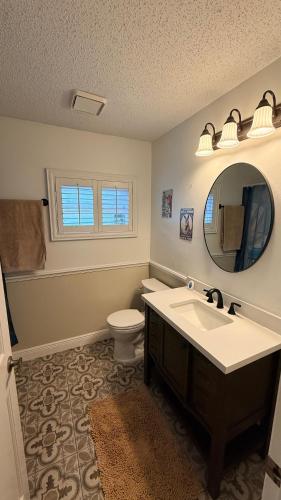 a bathroom with a sink and a toilet and a mirror at The little Manatee Retreat in Orlando