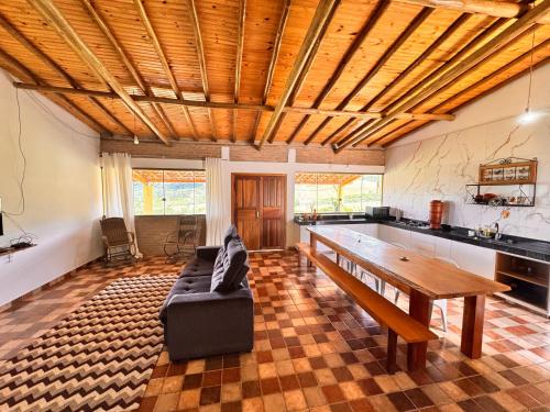 ein Wohnzimmer mit Sofa und Tisch in der Unterkunft Sítio Vista da Serra - Carrancas in Carrancas
