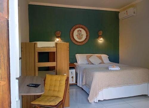 a bedroom with a bed and a table and a chair at Pousada Canto de Paz in Arraial d'Ajuda