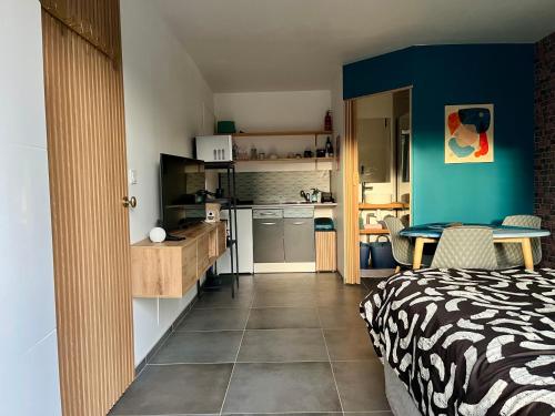 eine Küche und ein Schlafzimmer mit einem Bett und einem Tisch in der Unterkunft Blu'in - Mérignies in Mérignies