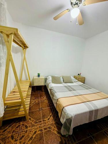 a bedroom with a bed and a ceiling fan at Comfortable House in Punta Hermosa