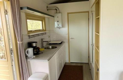 a small kitchen with a sink and a counter at DuinHut with Hottub in Ons Belang