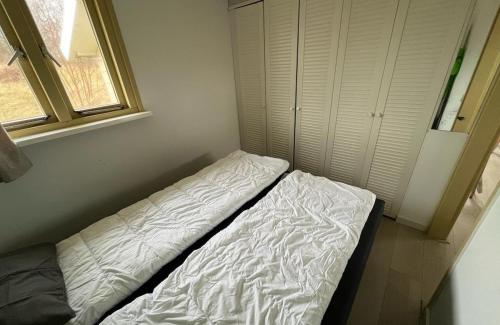 a bed in a small room with a window at DuinHut with Hottub in Ons Belang