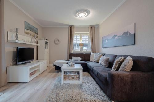 a living room with a couch and a tv at DünenZeit in List