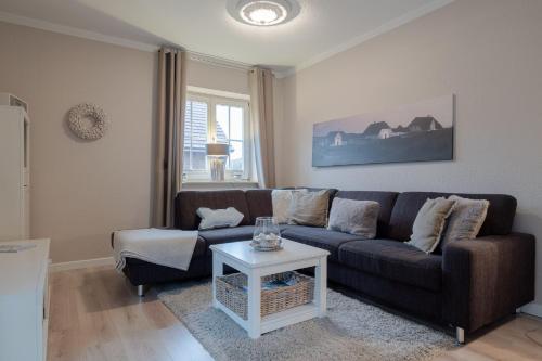 a living room with a couch and a table at DünenZeit in List