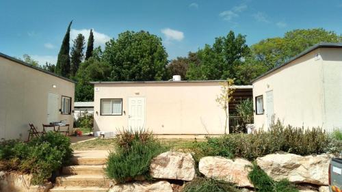 una casa bianca con un muro in pietra in un cortile di אירוח משק 42 a Sheʼar Yashuv