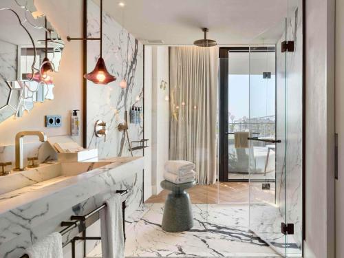 baño con encimera de mármol y lavabo en SLS Barcelona, en Barcelona