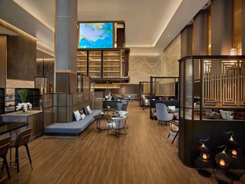 海防Pullman Hai Phong Grand Hotel的酒店大堂的墙上配有电视