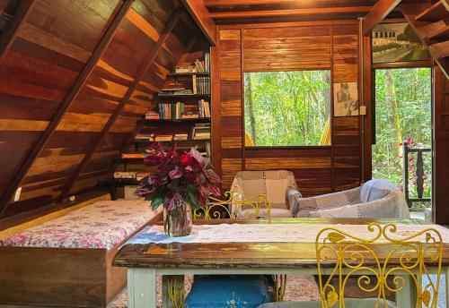 una stanza con un tavolo con un vaso di fiori sopra di Chalé Floresta Amada a Ouro Preto