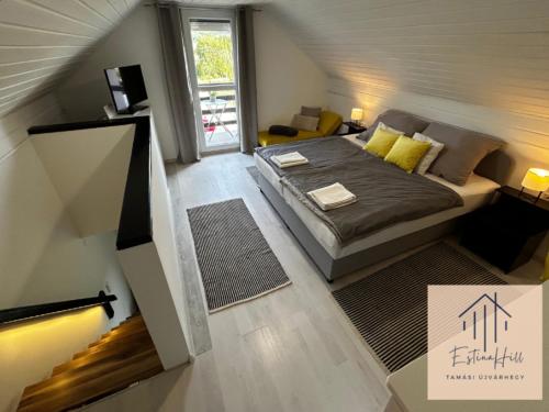 een kleine slaapkamer met een bed en een trap bij Estina Hill in Tamási