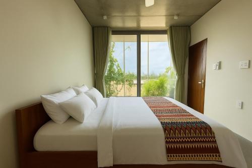 a bedroom with a large bed with a window at Marvelous Homestay Hoi An in Dien Ban