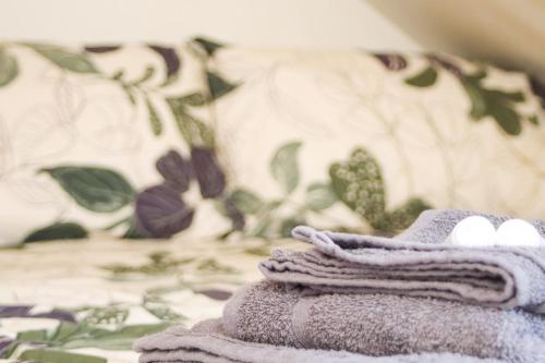 a pile of towels sitting on top of a bed at Pebbles Guest House - Flat 5 in Southampton