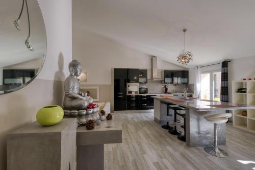 een keuken met een beeldje van een kind dat op een tafel zit bij Black & White in Alignan-du-Vent