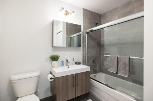 a bathroom with a toilet and a sink and a shower at Buchanan 609 - Midtown Condo Luxe and Gym in Montréal