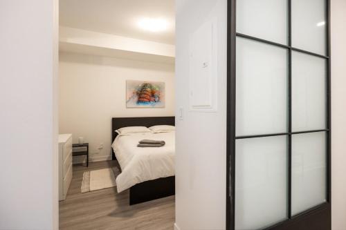 a bedroom with a white bed and a window at Buchanan 609 - Midtown Condo Luxe and Gym in Montréal