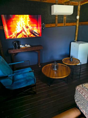 a living room with two tables and a fireplace at Oceans Bavarian Boutique Apartments in Maun