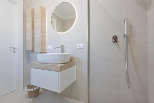 a white bathroom with a sink and a shower at Casa Nouè in Tertenìa