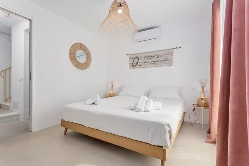 a white bedroom with a bed and a mirror at Casa Nouè in Tertenìa