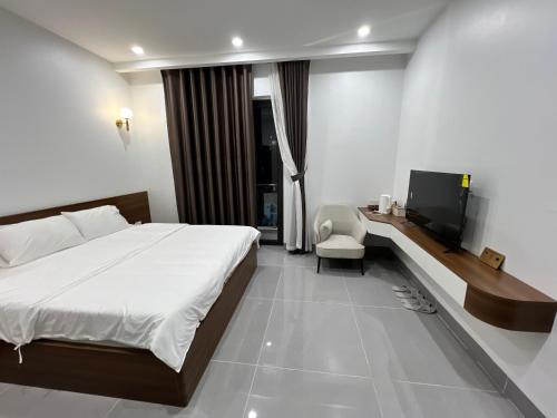 a hotel room with a bed and a tv at Tea hotel by Chiến Hảo in Ha Giang