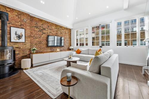 a living room with a couch and a brick wall at The Marylebone Villa in London
