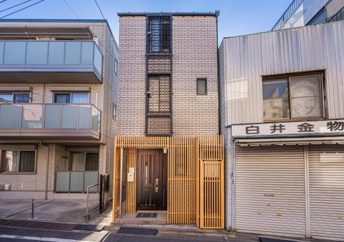 a building with a yellow door on a street at Family House 蕾 池袋徒步圈全新装修日式户建民宿 in Tokyo