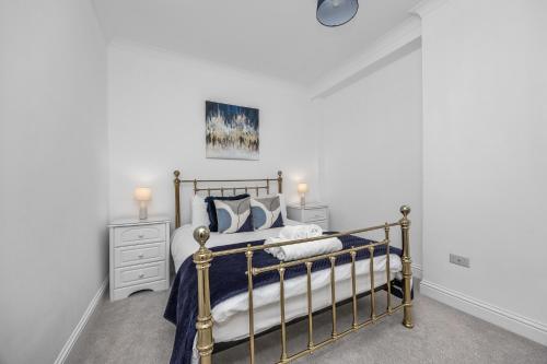 a bedroom with a bed with blue and white sheets at Spacious 2 Bed & 1 Bath - Close to Beach & City Centre in Brighton & Hove