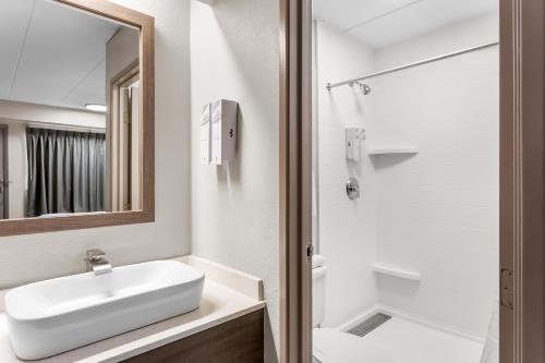 ホフマンエステーツにあるRed Roof PLUS Chicago - Hoffman Estatesの洗面台と鏡のある白いバスルーム