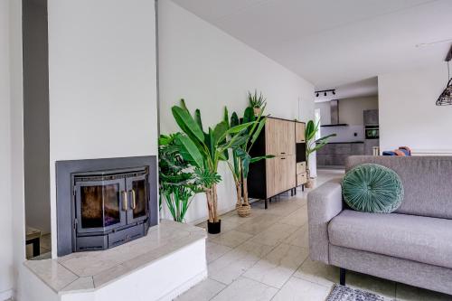 a living room with a fireplace and a couch at 12 - Persons Family Bungalow in Ewijk