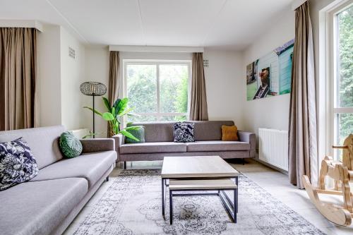 a living room with two couches and a table at 12 - Persons Family Bungalow in Ewijk