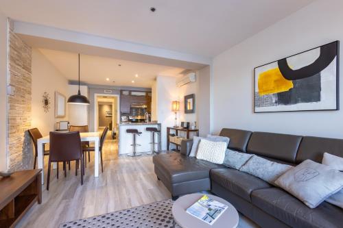 a living room with a couch and a dining room at Les Immeubles Charlevoix - Le 1175 in Quebec City