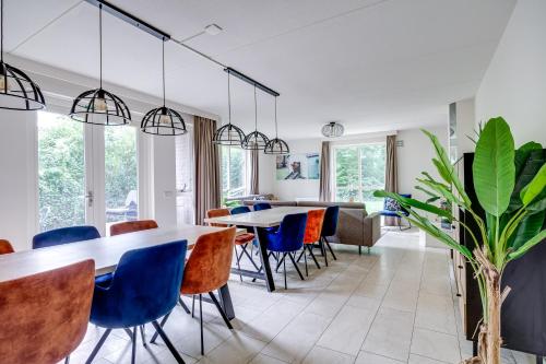 a dining room with blue chairs and tables at 12 - Persons Family Bungalow in Ewijk
