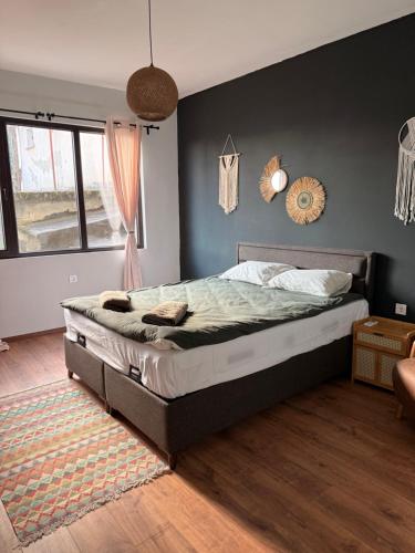 a bedroom with a bed with a gray wall at Boho Home in Veliko Tŭrnovo