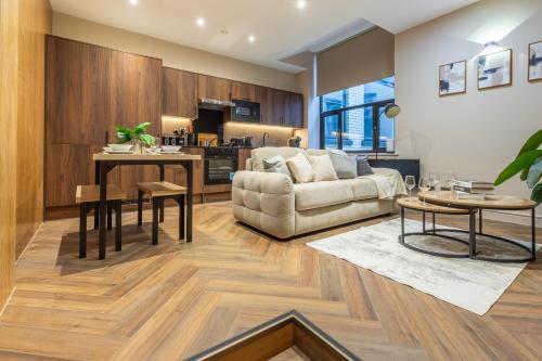 een woonkamer met een bank en een tafel bij Leeds City Centre Luxe Flats 8 mins to Station! in Central Station