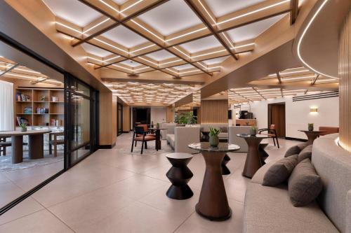 a lobby of a hotel with tables and chairs at The Stanley in Athens