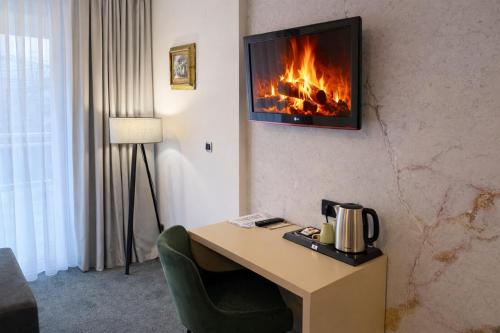 een kamer met een bureau en een open haard aan de muur bij Hotel Villa Harmony - Free Parking in Sarajevo