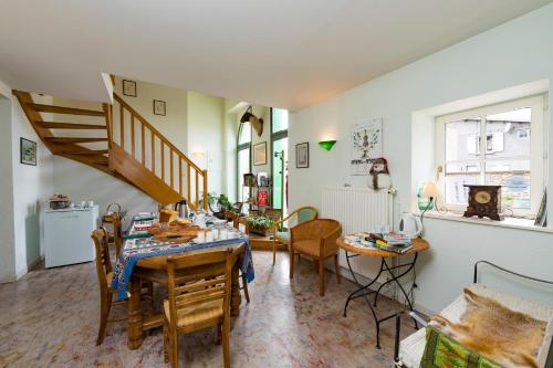 Soulosse-sous-Saint-ÉlopheにあるDessine moi un mouton, chambre d'hôte à Soulosseのリビングルーム(テーブル、椅子、階段付)