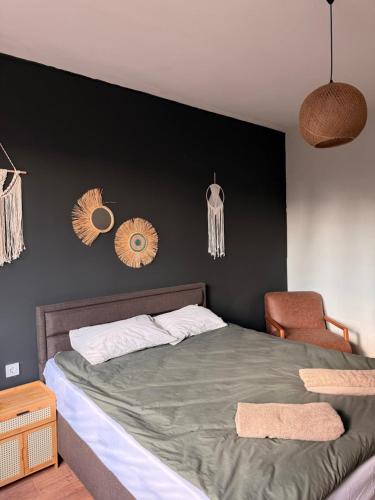 a bedroom with a bed and a black wall at Boho Home in Veliko Tŭrnovo