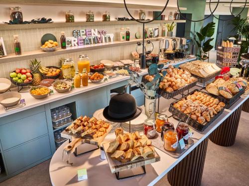 ein Buffet mit vielen verschiedenen Speisen in der Unterkunft Ibis Styles Madrid Airport Valdebebas in Madrid