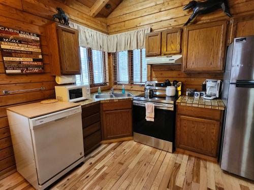 a kitchen with wooden cabinets and a refrigerator at Private Cabin-Shuttle Pass Included! in Thompsonville