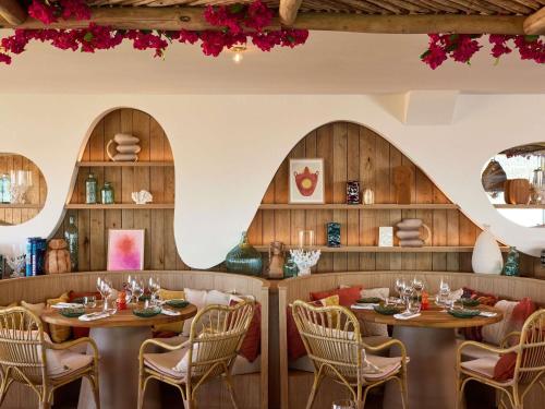 een restaurant met houten wanden en tafels en stoelen bij Le Talaia Hôtel & Spa Biarritz - MGallery Collection in Biarritz