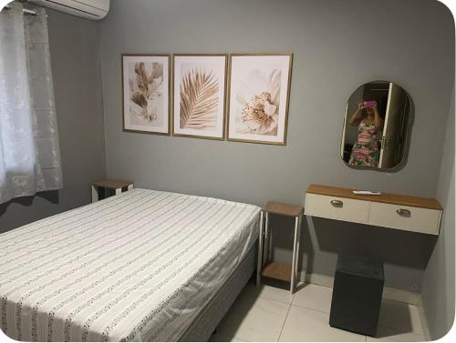 a bedroom with a bed and a desk and a mirror at Casa Maragogi in Maragogi